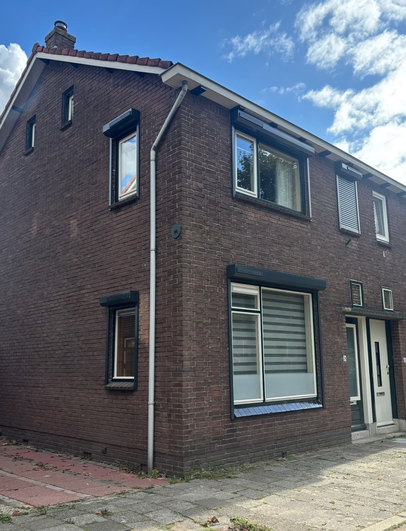 Antracietgrijze rolluiken op maat op een hoekwoning, op zonne-energie zonder kabels