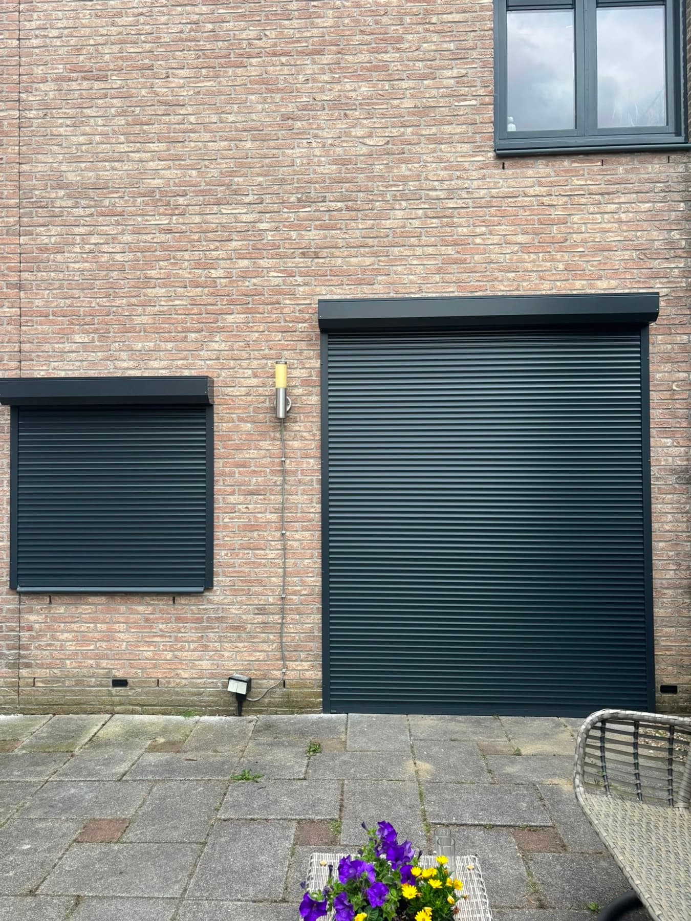 Antracietgrijze rolluiken op maat, gemonteerd op een achtergevel